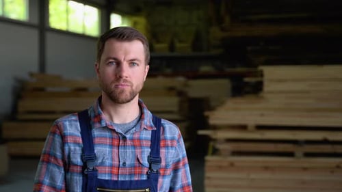 Young Male Worker in Timber Lumber Warehouse Wooden Boards Lumber Industrial Wood Timber Pine Wood