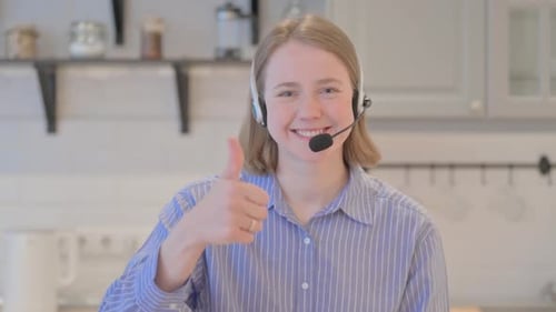 Thumbs Up by Young Woman with Headset in Call Center