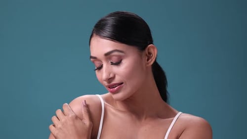 A 4K stock video of an attractive young female posing gracefully against a white studio background.