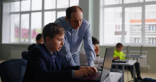 Adolescente consultando con un profesor en el aula, un futuro programador que estudia en la escuela