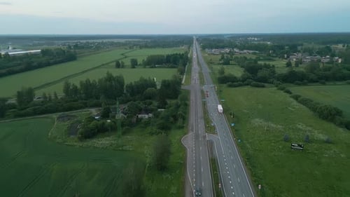 Enjoy the Aerial View of a Countryside Road Extending Towards the Horizon Amidst Lush Greenery and