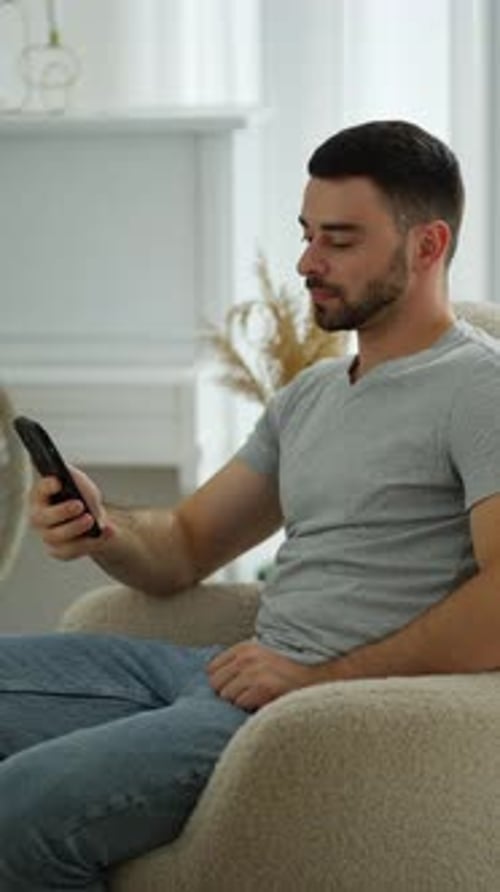 Man Relaxing at Home with smartphoneConcept of Home Comfort Digital Connectivity Leisure