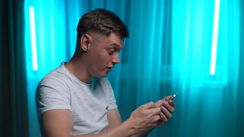 Man Reacting Happily to Content on Smartphone