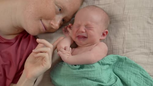 Mother Comforts her Newborn Infant Baby