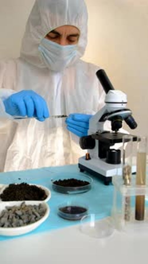 Scientist Analyzing Soil Sample Under Microscope