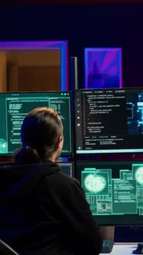 Hacker Working at Computer with Multiple Monitors