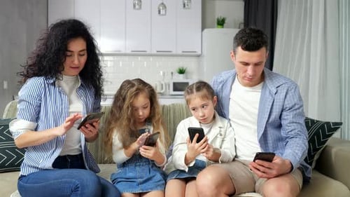 Family Sits Looking at Smartphones and Explores Internet