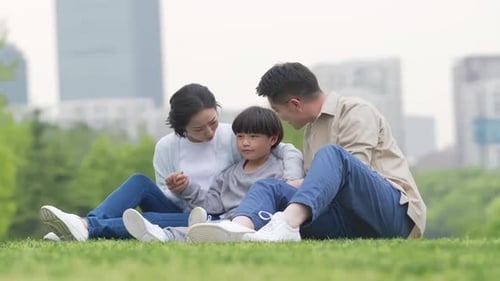 Happy family in the outdoor outing having a picnic in the park