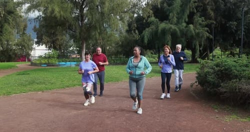 Fit Senior People Running at City Park - Group of Elderly Friends