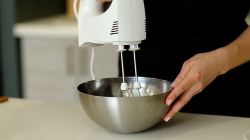 Woman Uses Electric Mixer in Stainless Steel Bowl