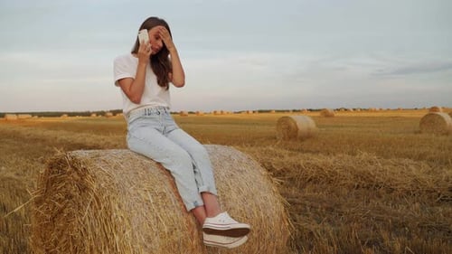 Woman Talking on Cell Phone in a Rural Field