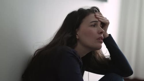 Nervous woman suffering from depression sitting on floor. Frustrated person in mental anguish