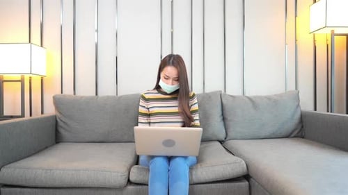 Woman Working from Home on Gray Couch
