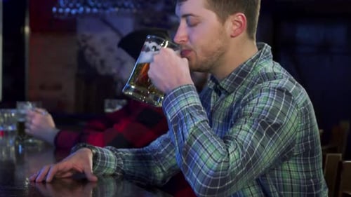 Cheerful Guy Raising a Beer at the Pub