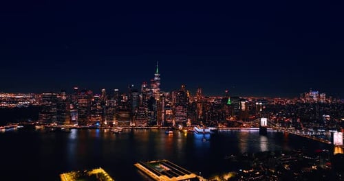 Approaching the skyline of vibrant New York with amazing illumination. Vast city panorama at night.