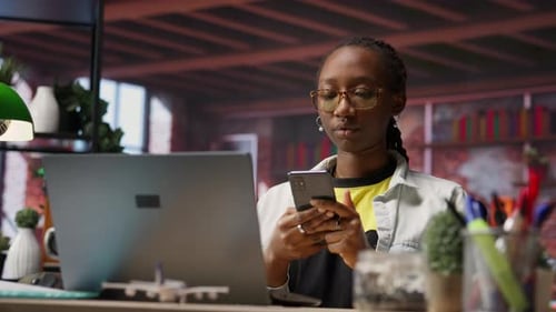 Smiling Woman Using Cellphone in Home Office
