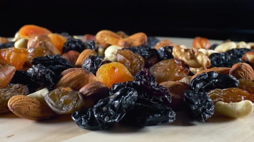 Close up Hand Picks Dried Fruit and Nuts