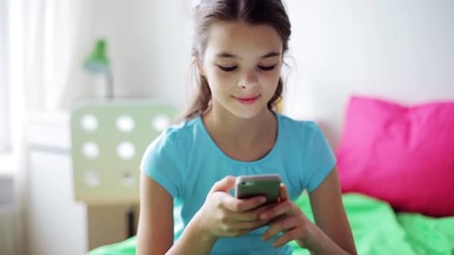 Teenage Girl Using Mobile Phone on Bed