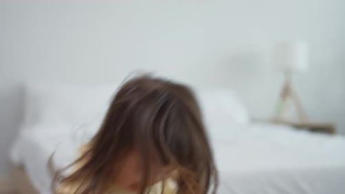 A cheerful kid girl playing and running with loving parents in house.
