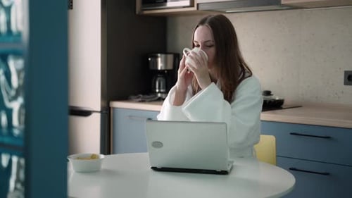 Fair Haired Woman Works on Laptop at Home