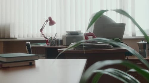 Leerer Arbeitsplatz mit großem Monitor und Papieren auf dem Schreibtisch im Retro-Büro