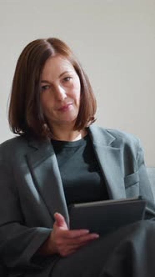 Businesswoman Using Digital Tablet While Seated in Minimalist Office Lounge