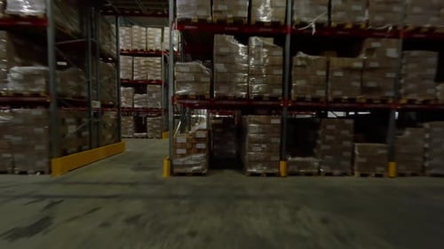 Entrepôt garni d'étagères métalliques empilées avec des boîtes en carton