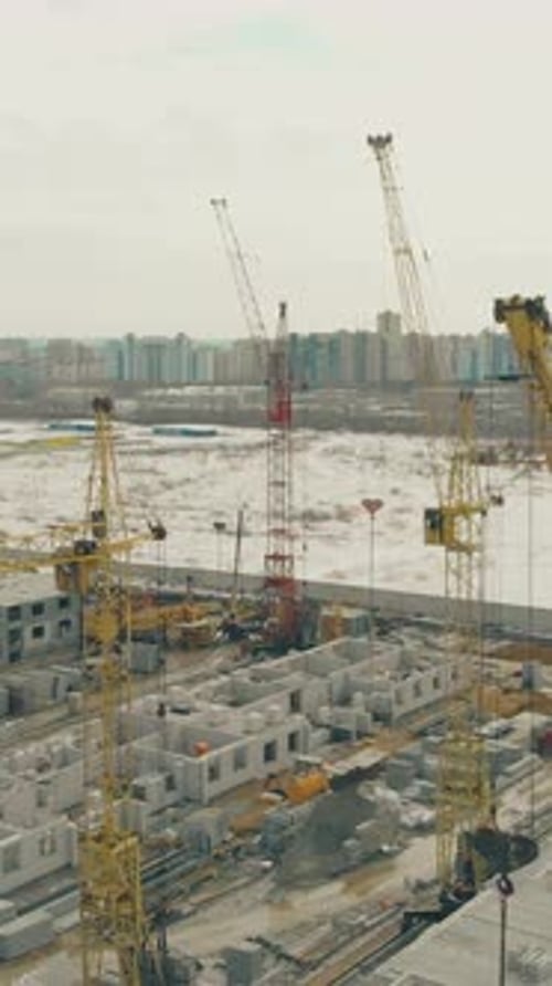 Grúas de torre en el sitio de construcción el día de invierno: Vista superior