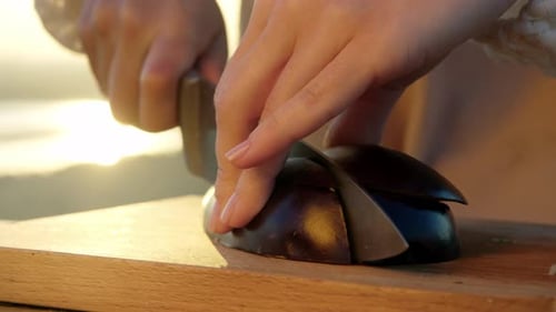 La berenjena madura se corta en mitades a la luz de la mañana, creando una opción de desayuno saludable