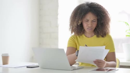 Stressed Woman Reviews Documents in Office