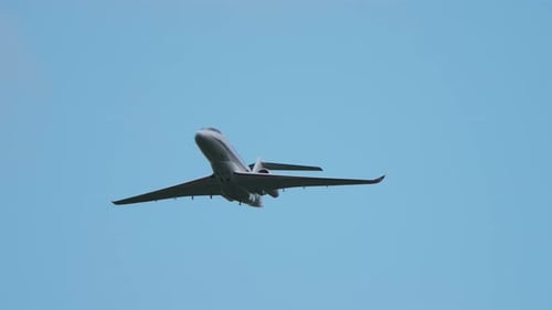 Private Business Jet Flying in Clear Blue Sky Front View