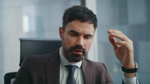 Stressed Businessman Talking on Phone in Office