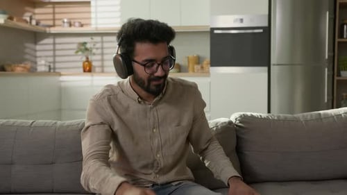 Man Relaxing on Sofa Listening to Music