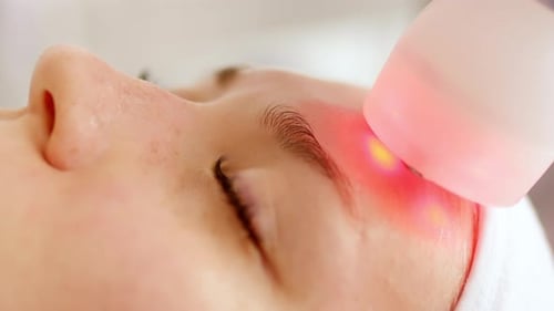 Cosmetic Procedure with Light-Up Tool Near Woman's Eye