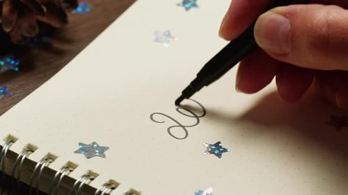 Hads Writting Some Goals Purposes on List on Wooden Desk Surrounded By Christmas Decorations and