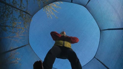 Woman Jumps High on Trampoline Extreme Angle From Bottom Enjoying Fun Jumping