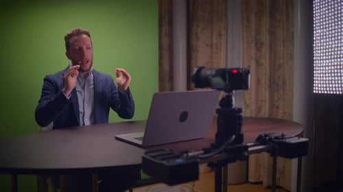 Expert Professional Presenter in a WellEquipped Studio Utilizing a Green Screen Setup for Visuals