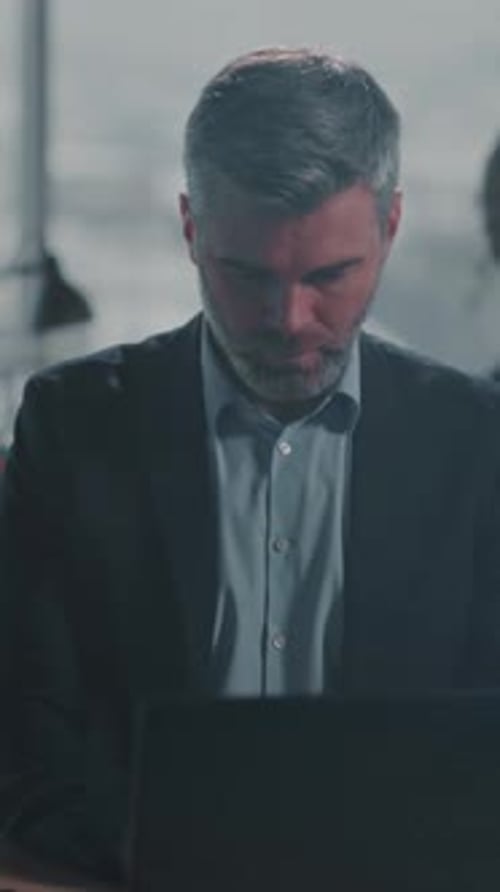 Office Worker Focused on Nighttime Tasks Individual Diligently Reviewing Data Amidst Evening Office