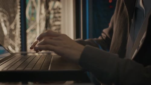 Close Up of Hands Typing on Laptop by Server