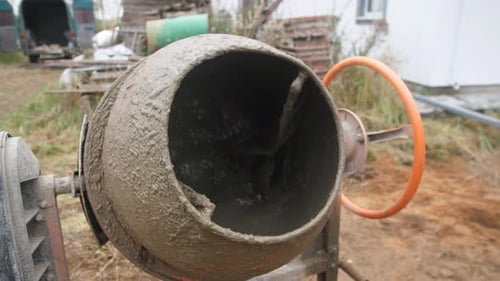 Cement mixer mixes cement outside during the daytime