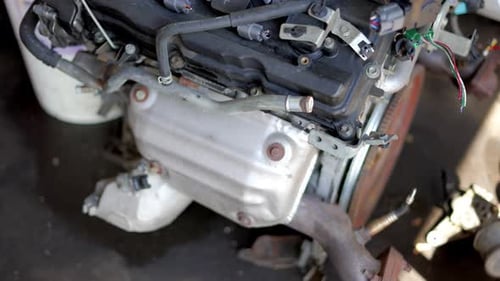 Big block engine V8 or V6 4 cylinder sitting on concrete ground floor in mechanics garage shop havin