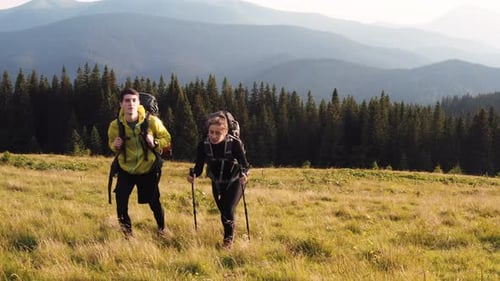 Couple of tourists walks up on hill. Majestic Carpathian Mountains. Beautiful landscape of untouched