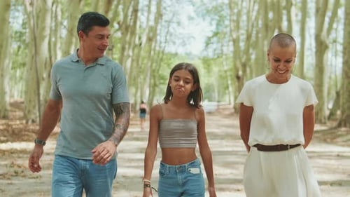 Happy family walking and talking along the path in the park