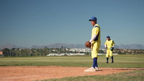 Baseball Players in Yellow Uniforms Practicing Fielding on a Sunny Outdoor Field