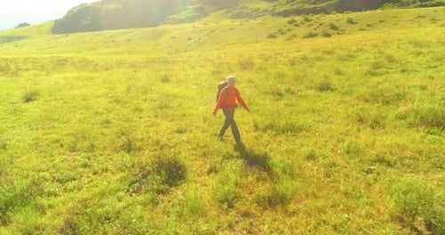 Flight Over Backpack Hiking Tourist Walking Across Green Mountain Field