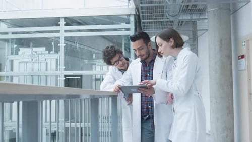 Group of Students of Medical School have Meeting in College Hallway. Looking at Tablet Computer. Ha