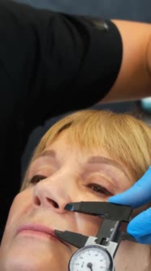 Medical Professional Measuring a Woman's Face with Caliper