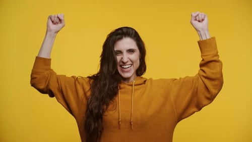 Woman Cheerfully Raising Arms in Celebration