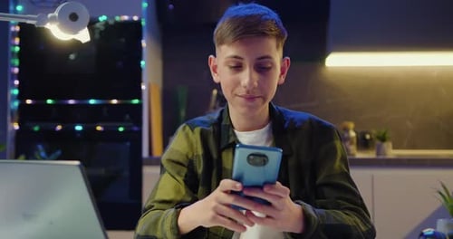 Teen Using Smartphone Indoors at Night