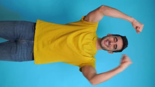 Excited Man with Raised Arms in Studio
